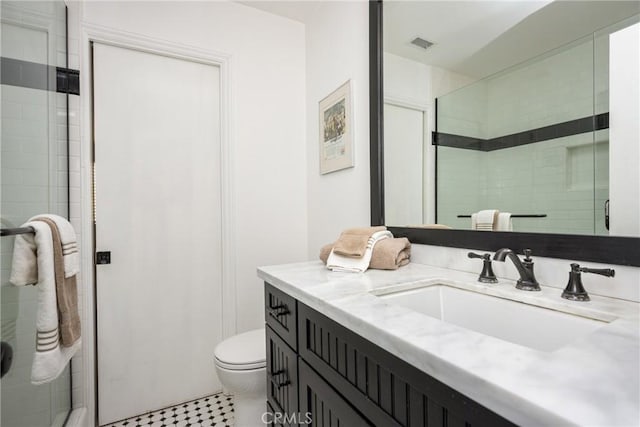 bathroom with toilet, vanity, visible vents, and a shower stall
