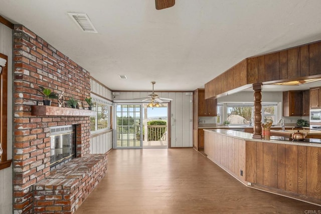 kitchen featuring ceiling fan, wood finished floors, a healthy amount of sunlight, and stainless steel microwave