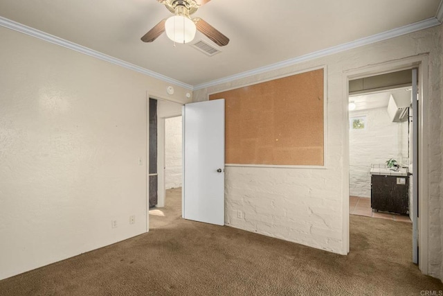 unfurnished bedroom with visible vents, ceiling fan, ornamental molding, and carpet flooring