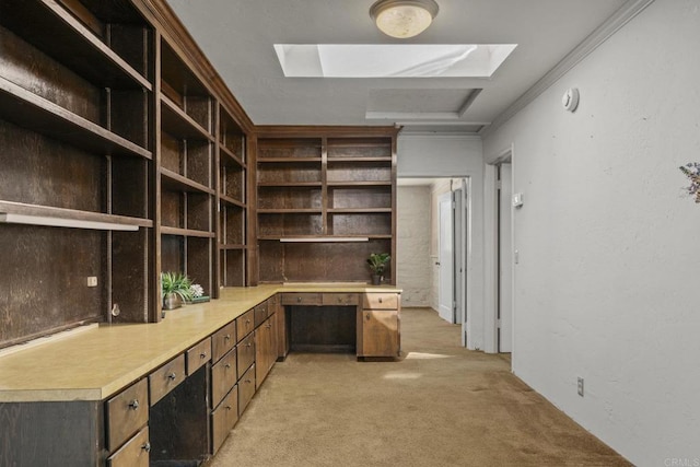 unfurnished office with ornamental molding, a skylight, and light colored carpet