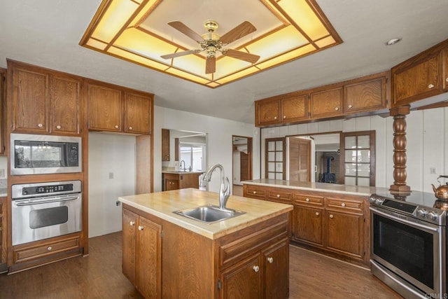 kitchen with a sink, appliances with stainless steel finishes, and brown cabinets