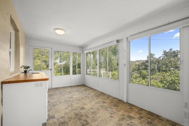 unfurnished sunroom with a sink and a healthy amount of sunlight