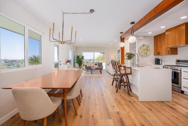 dining room featuring a notable chandelier, light wood-style flooring, and recessed lighting