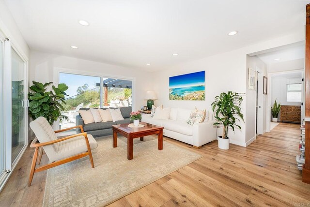living area with light wood finished floors and recessed lighting