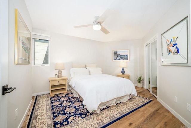 bedroom featuring a ceiling fan, baseboards, and wood finished floors