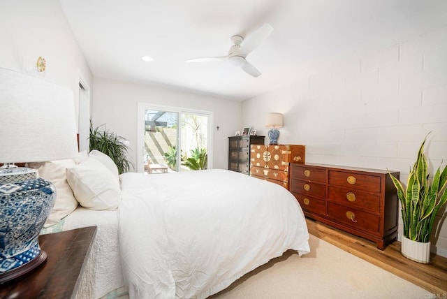 bedroom featuring access to exterior, light wood-style flooring, and a ceiling fan
