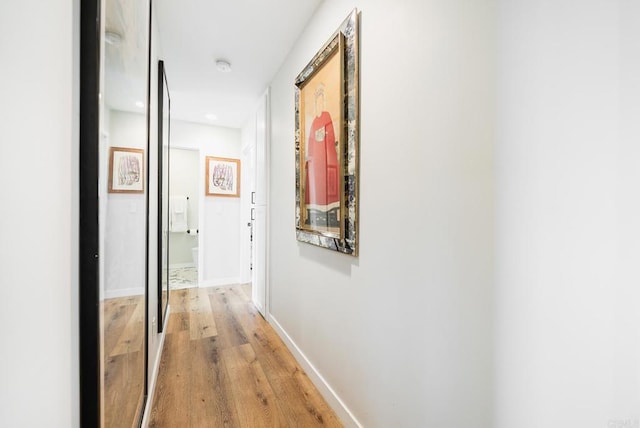 hallway with baseboards and light wood finished floors