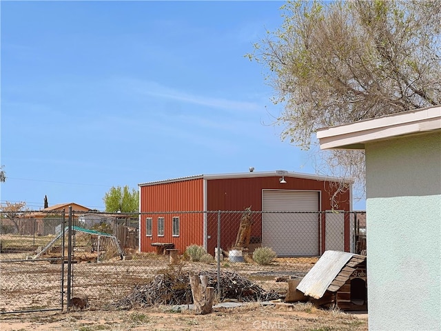 view of outdoor structure featuring fence and an outbuilding