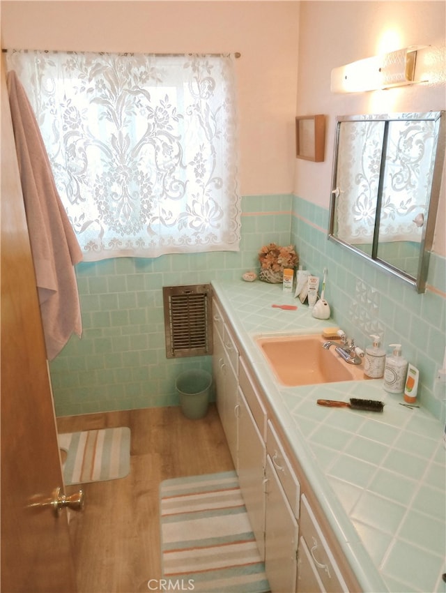 bathroom with vanity, visible vents, tile walls, and wood finished floors