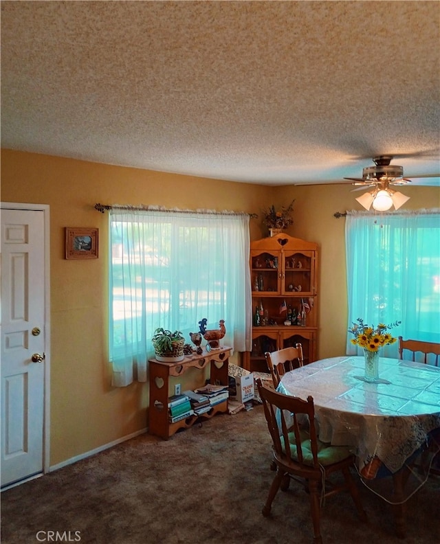 carpeted dining space with a textured ceiling and ceiling fan