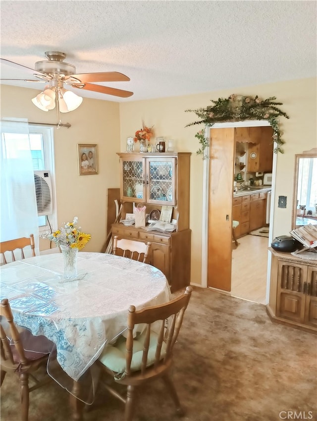 dining area with cooling unit, a textured ceiling, light carpet, and a ceiling fan