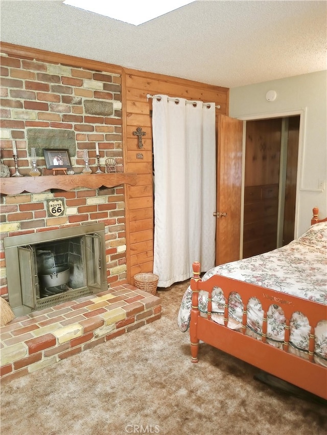 carpeted bedroom with a textured ceiling and a fireplace