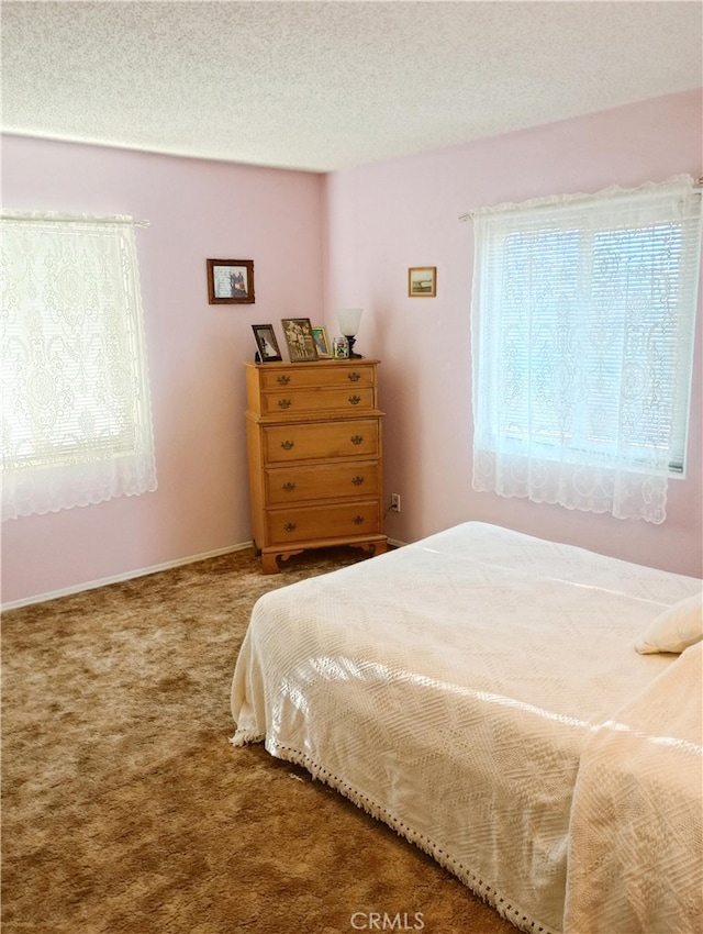 bedroom with a textured ceiling and carpet flooring