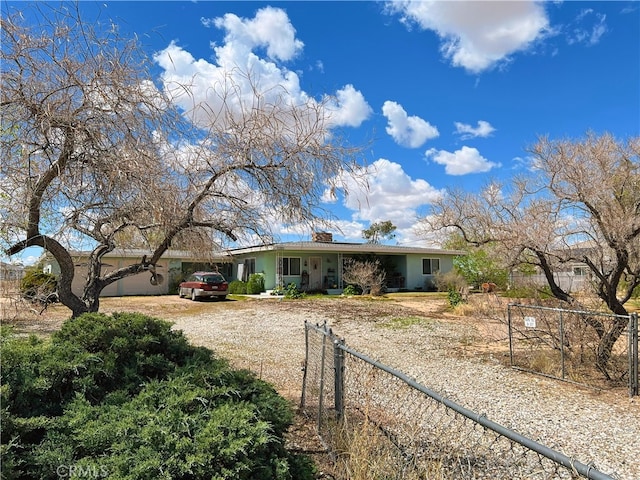 ranch-style house featuring fence, stucco siding, driveway, and roof mounted solar panels