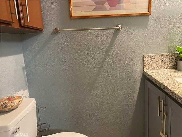 698 W Phillips Blvd, Pomona, CA 91766 - half bath with a textured wall, toilet, and vanity