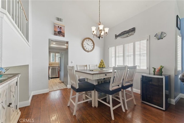 3140 Timberline Dr, Corona, CA 92882 - dining space with a chandelier, wood-type flooring, visible vents, and a towering ceiling