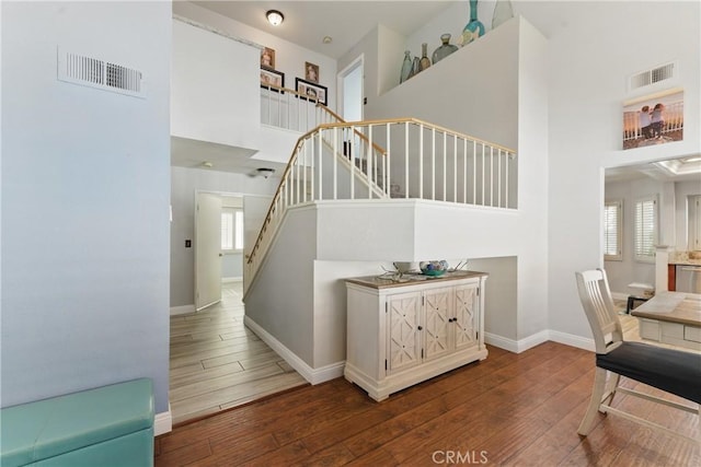 3140 Timberline Dr, Corona, CA 92882 - stairs featuring visible vents, wood-type flooring, plenty of natural light, and a towering ceiling