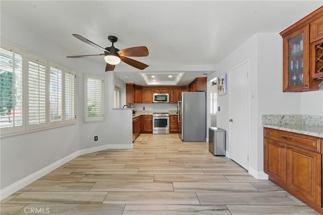 3140 Timberline Dr, Corona, CA 92882 - kitchen featuring baseboards, ceiling fan, appliances with stainless steel finishes, wood tiled floor, and brown cabinets