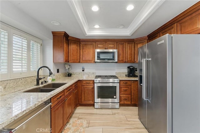 3140 Timberline Dr, Corona, CA 92882 - kitchen featuring a sink, brown cabinets, a tray ceiling, light stone countertops, and stainless steel appliances