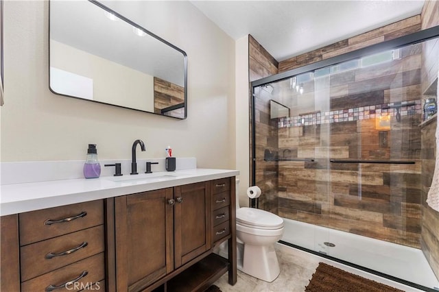 bathroom featuring toilet, a shower stall, and vanity