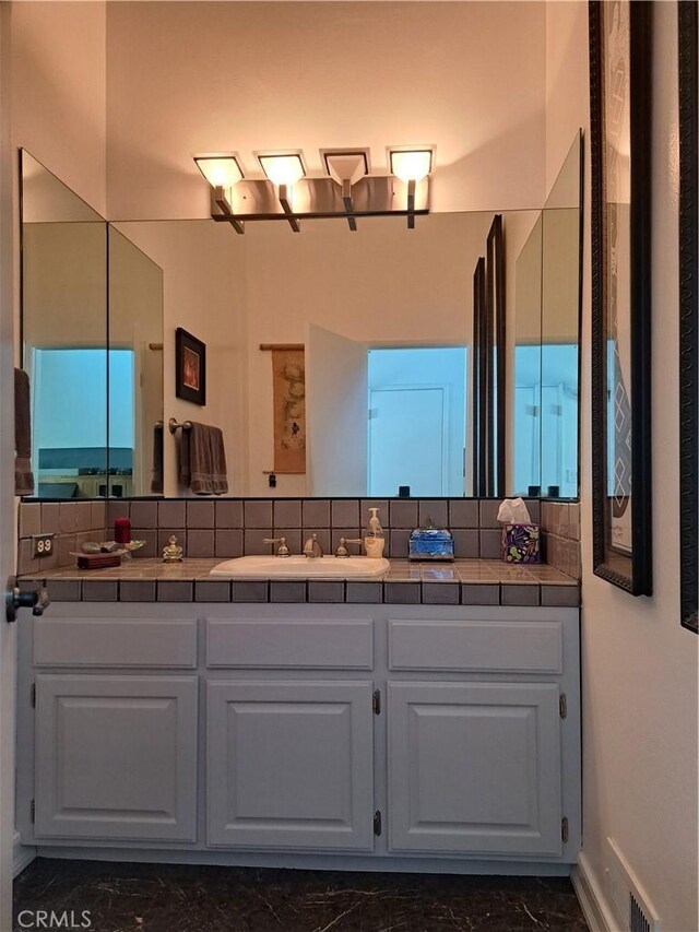 21651 Yucatan Ave, Woodland Hills, CA 91364 - bathroom featuring marble finish flooring, vanity, tasteful backsplash, and baseboards