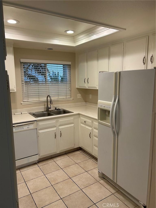 kitchen featuring light countertops, a raised ceiling, light tile patterned floors, a sink, and white appliances
