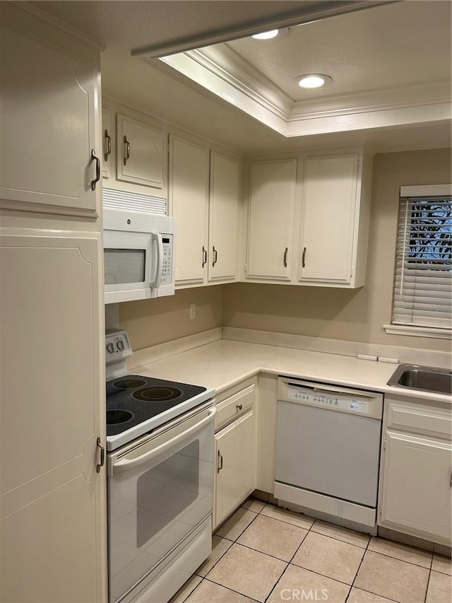 kitchen with ornamental molding, light countertops, white appliances, and a raised ceiling