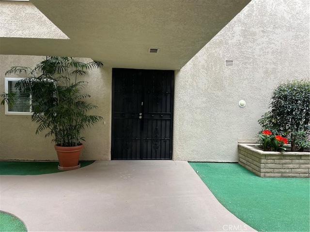 2370 Via Mariposa W Unit 1B, Laguna Woods, CA 92637 - view of exterior entry featuring stucco siding