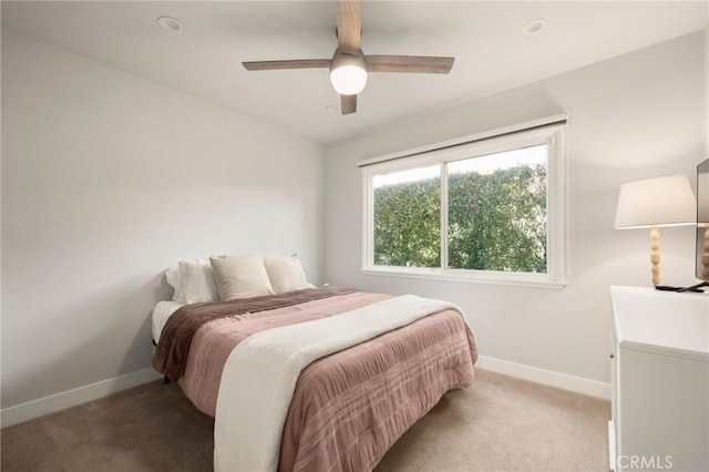 carpeted bedroom featuring a ceiling fan and baseboards