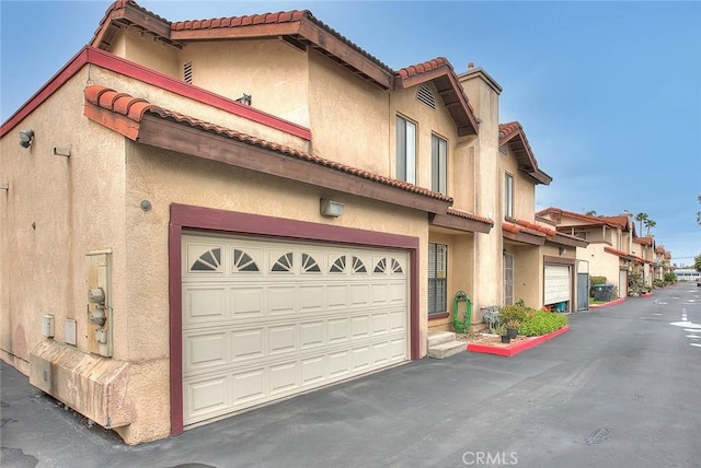 4018 W 5th St Unit J, Santa Ana, CA 92703 - exterior space with stucco siding, an attached garage, and a tile roof
