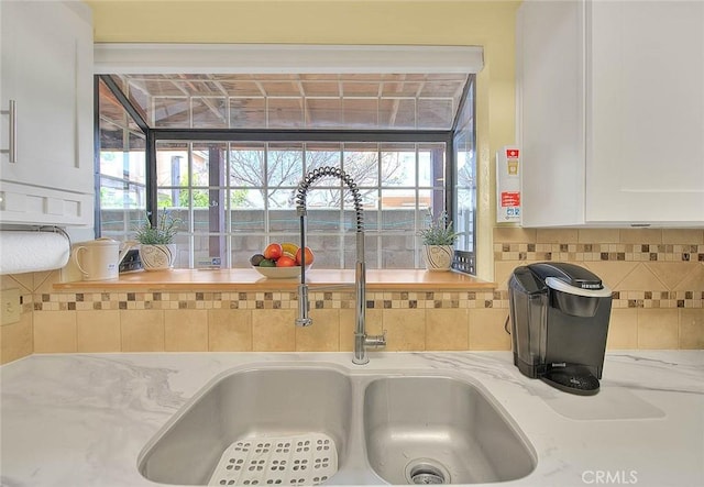 4018 W 5th St Unit J, Santa Ana, CA 92703 - interior details with backsplash, white cabinetry, light stone countertops, and a sink