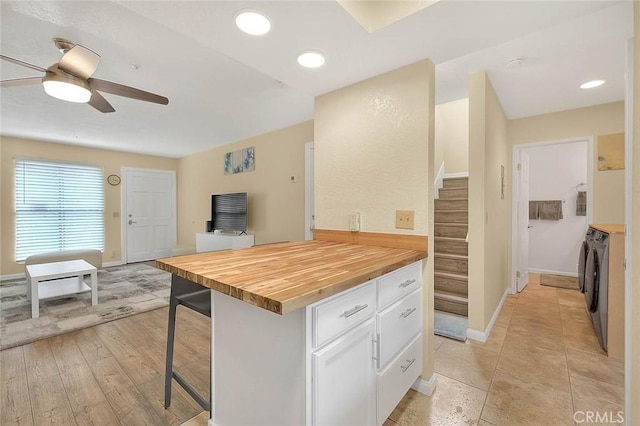 4018 W 5th St Unit J, Santa Ana, CA 92703 - kitchen featuring washer and clothes dryer, white cabinetry, ceiling fan, butcher block counters, and a breakfast bar