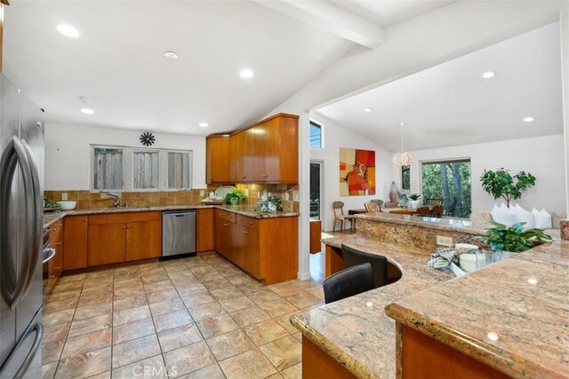 2377 Silver Ridge Ave, Los Angeles, CA 90039 - kitchen featuring appliances with stainless steel finishes, tasteful backsplash, brown cabinetry, light stone countertops, and recessed lighting