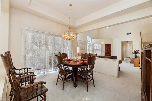 dining room with a chandelier, a towering ceiling, light carpet, and visible vents