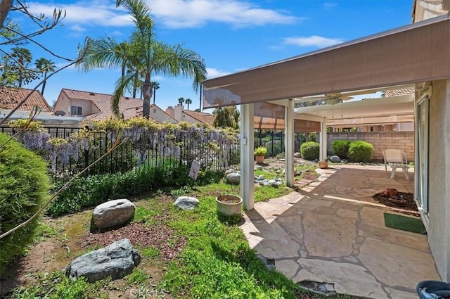 view of yard featuring a fenced backyard, ceiling fan, and a patio area