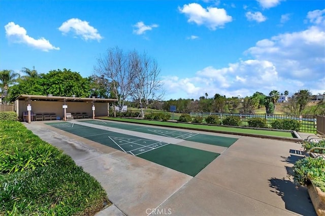 view of community featuring shuffleboard and fence