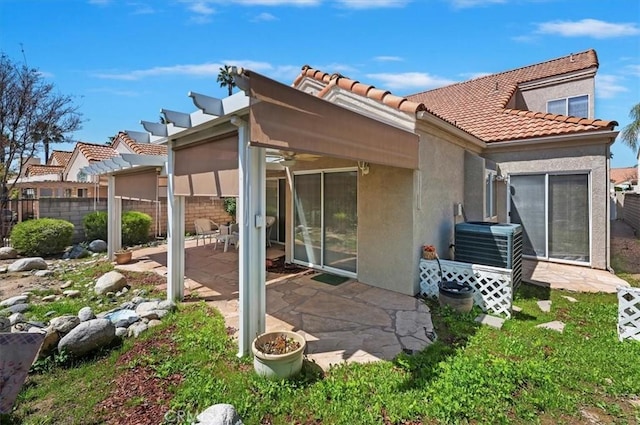 back of property featuring a tiled roof, fence, ceiling fan, a patio area, and stucco siding