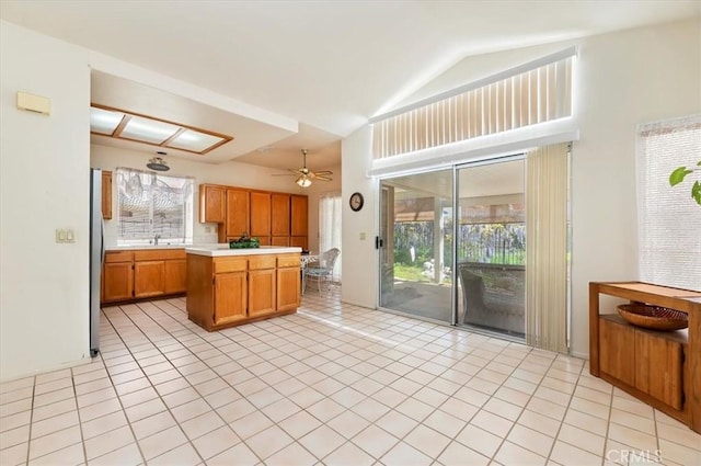 kitchen with a sink, light tile patterned flooring, light countertops, and a healthy amount of sunlight