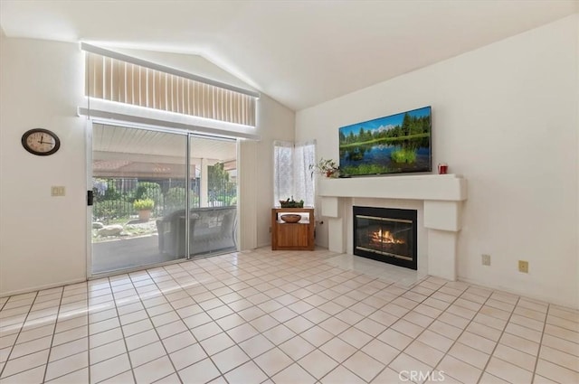 tiled living area featuring lofted ceiling and a glass covered fireplace