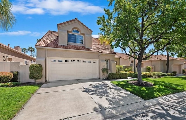 mediterranean / spanish-style home featuring a tile roof, a front yard, stucco siding, and driveway