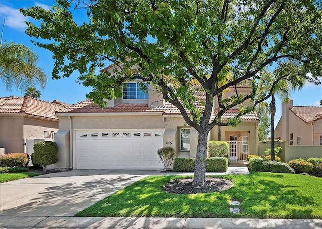 view of front of property with driveway, a garage, stucco siding, a tile roof, and a front lawn