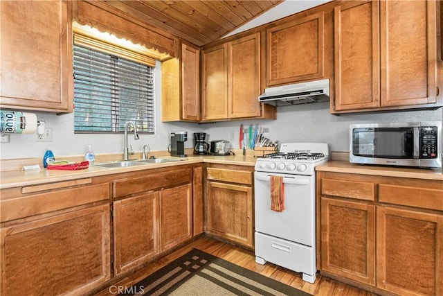 212 Vista Ln, Sugarloaf, CA 92386 - kitchen featuring light countertops, stainless steel microwave, under cabinet range hood, a sink, and white gas range oven