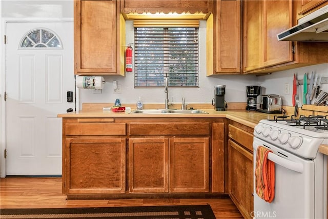 212 Vista Ln, Sugarloaf, CA 92386 - kitchen featuring light countertops, wood finished floors, under cabinet range hood, a sink, and white gas range oven