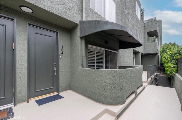 14919 Dickens St Unit 104, Sherman Oaks, CA 91403 - doorway to property featuring stucco siding and a balcony