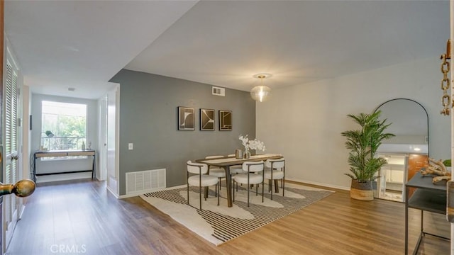 dining room featuring visible vents, baseboards, and wood finished floors