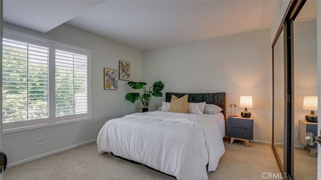 bedroom featuring baseboards and light colored carpet