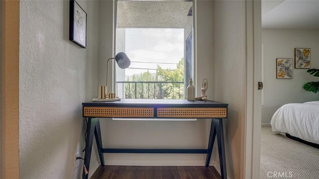 interior details with baseboards, a textured wall, and wood finished floors