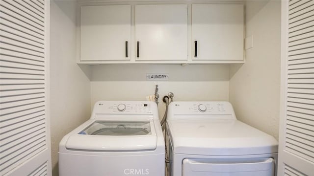 washroom with cabinet space and washing machine and dryer