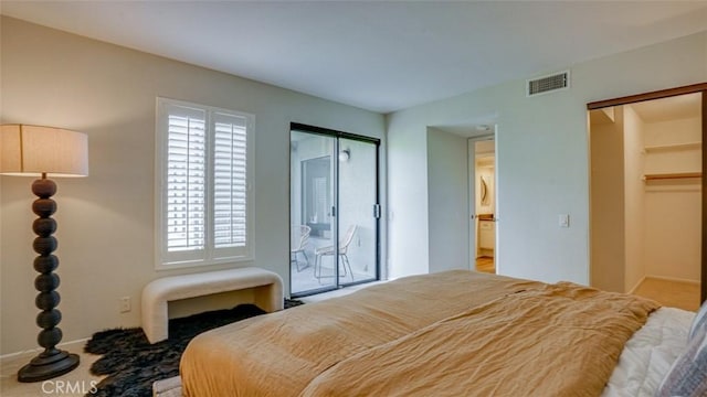 bedroom featuring visible vents, a walk in closet, and carpet