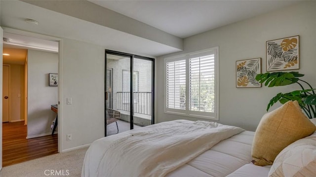 carpeted bedroom featuring baseboards and access to exterior